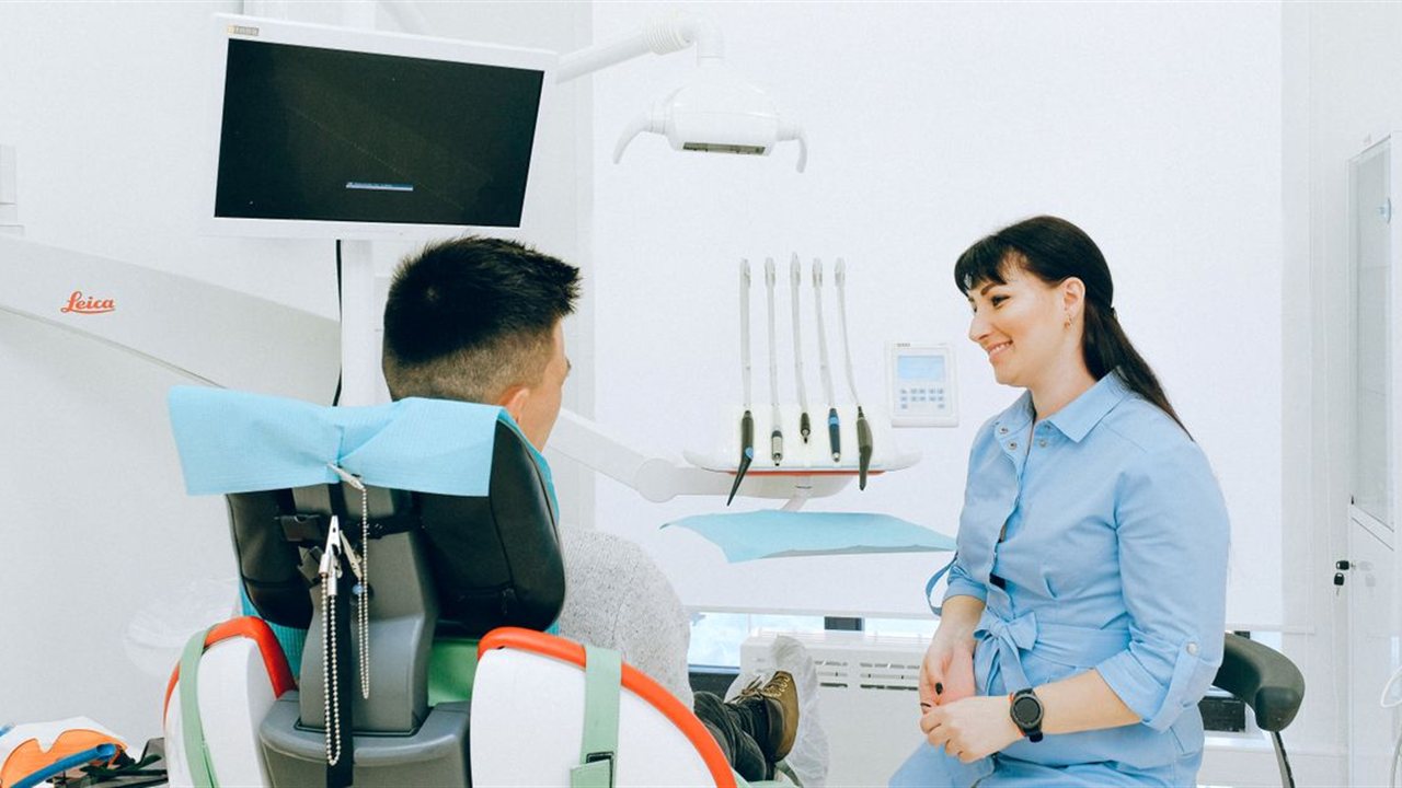 A friendly clinician welcoming a new patient in a modern treatment room at The Village Dentist