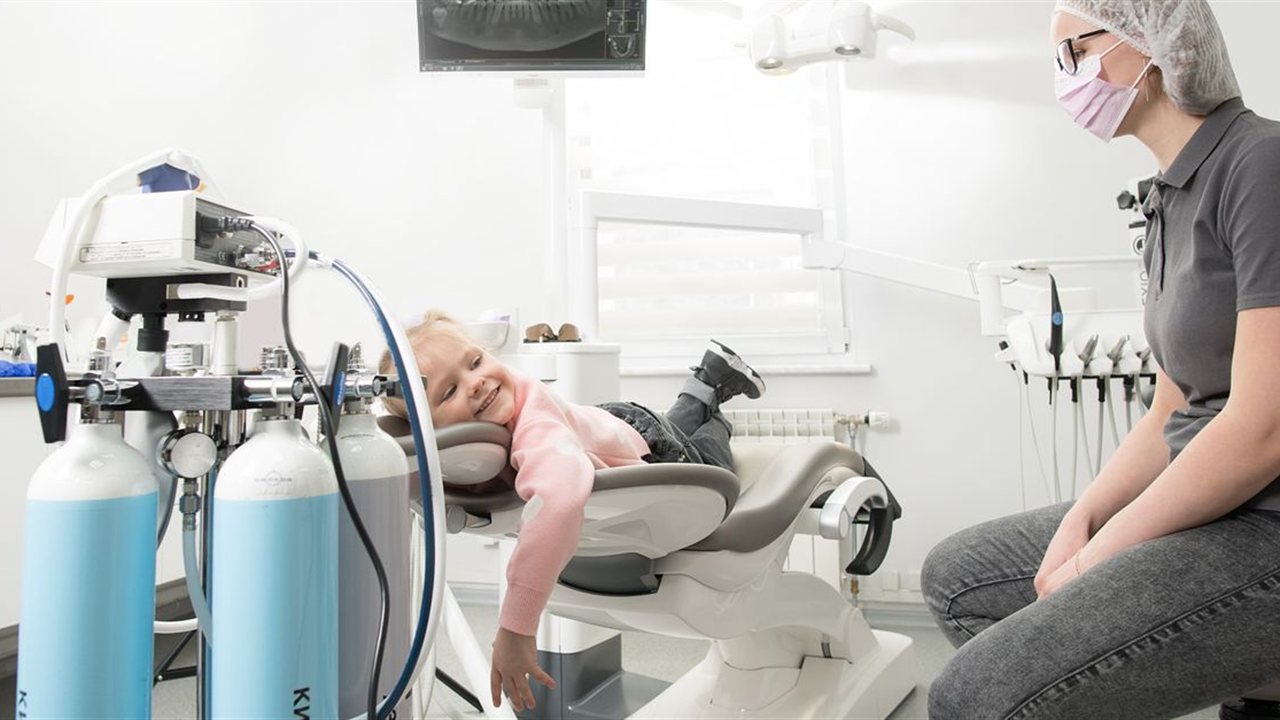 A child smiling in the dental chair at a family dentist in Bloor West Village, Toronto.