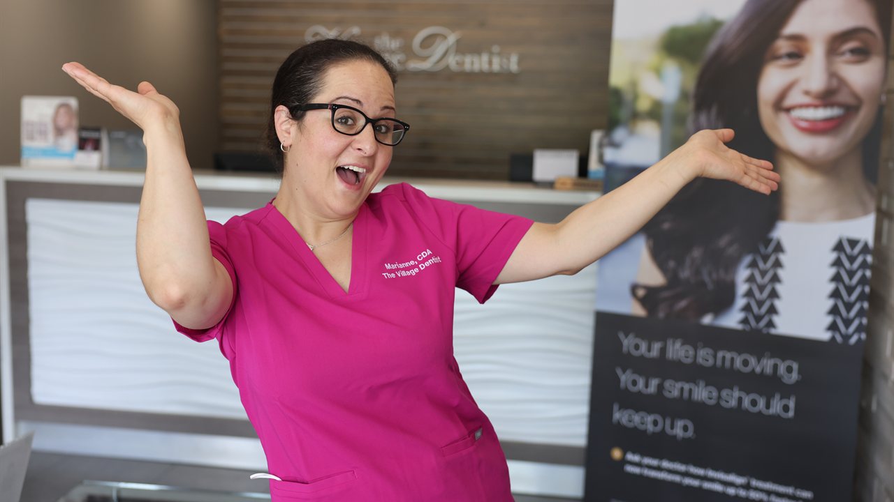Marianne welcoming patients at The Village Dentist front desk in Bloor West Village, Toronto